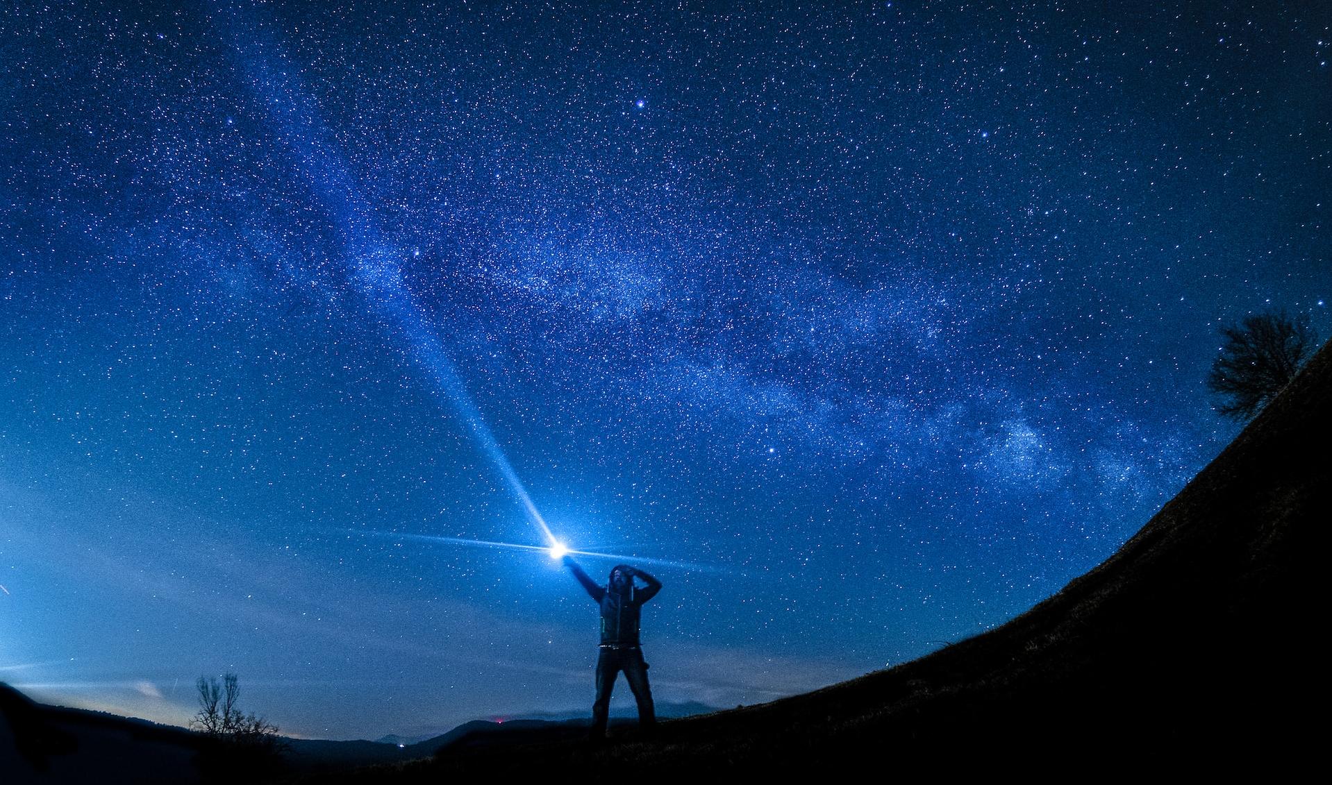 silhouette of man holding flashlight